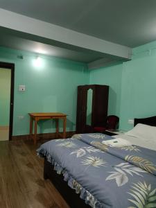 a bedroom with two beds and a wooden table at Hotel PineWood Tawang in Tawang