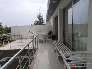 a balcony with benches and tables on a building at Magic Beach Apartments in Kyrenia