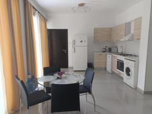 a kitchen with a table and chairs in a kitchen at Magic Beach Apartments in Kérynia +16 photos