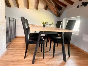 a dining room with a wooden table and black chairs at Domus 44 Rooms - Porta Nuova in Verona