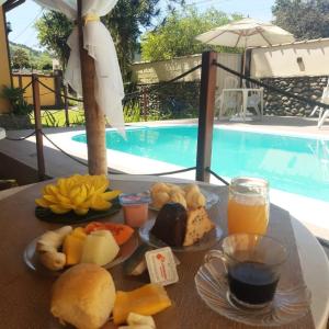 a tray of food on a table next to a pool at Vale do Pontal Angra in Angra dos Reis