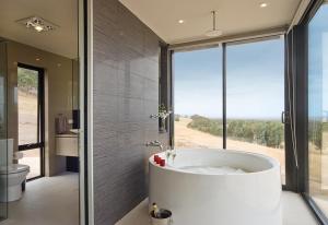 uma grande casa de banho com banheira e uma grande janela em McLaren Eye em Kangarilla