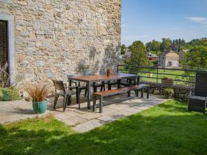 een houten tafel en banken op een patio bij Charming cottage in Gimn e in Doische