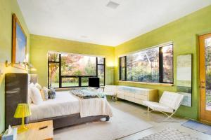 - une chambre avec des murs jaunes, un lit et des fenêtres dans l'établissement Eclectic Mountain Retreat, à Hailey