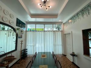 a dining room with a green table and chairs at 1-BR spacious lofted apartment near BGC Taguig City (THR105) in Manila