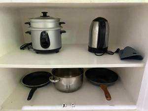 a kitchen shelf with a coffee maker and pots and pans at 1-BR spacious lofted apartment near BGC Taguig City (THR105) in Manila