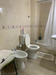 a bathroom with a toilet and a sink and a tub at Dpto Alvear in Chivilcoy