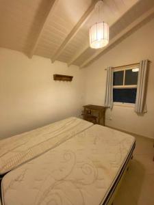 um quarto com uma cama num quarto com uma janela em Esplendor House - Little Cambury em São Sebastião