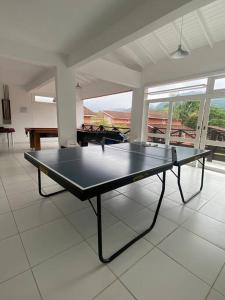 a ping pong table in the middle of a room at Esplendor House - Little Cambury in São Sebastião