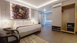 查亞普拉的住宿－SIP Azana Hotel Jayapura，卧室配有一张床,墙上挂有绘画作品