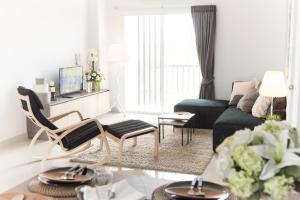 a living room with a green couch and a table at Zada Residence in Nakhon Ratchasima
