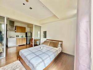 1 Schlafzimmer mit einem großen Bett und einer Küche in der Unterkunft Stayover at Azure in Manila