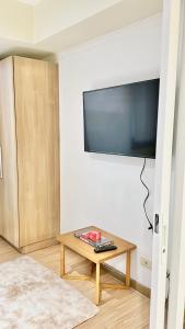 ein Wohnzimmer mit einem Tisch und einem Flachbild-TV in der Unterkunft Stayover at Azure in Manila