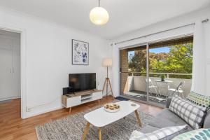 a living room with a couch and a tv at 22 Superb Subiaco Apt For Couplesparkng in Perth