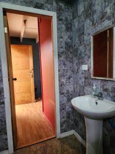 een badkamer met een witte wastafel en een rode deur bij Kalas Cabañas in Puerto Varas