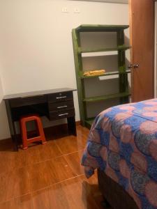 1 dormitorio con escritorio, 1 cama y 1 mesa en Namaste House, en Cusco