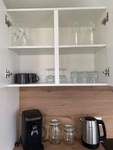 uma cozinha com frascos de vidro transparente e comodidades para preparar café em Nisay Home - 3 Room Apartment - Nr1 em Ludwigsburg