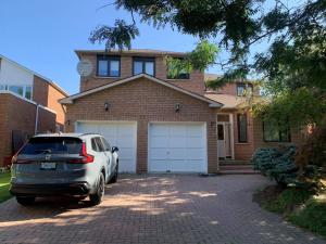 a car parked in front of a brick house at Markham private room in Markham