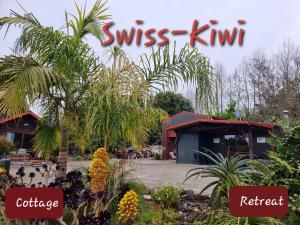 um sinal que lê kiwi suíço e um restaurante em Swiss-Kiwi Retreat A Self-contained Appartment or a Tiny House option em Tauranga