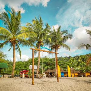 - une balançoire sur une plage avec des palmiers dans l'établissement Samba Bluewater Resort, à Olongapo