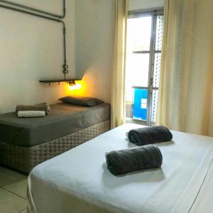 2 Einzelbetten in einem Zimmer mit Fenster in der Unterkunft Micasa Hostel - Congonhas in São Paulo