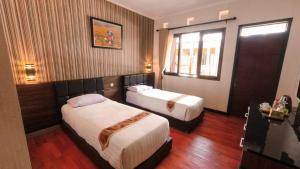 a hotel room with two beds and a window at Kebun Teh Wonosari Rollaas Hotel & Resort in Malang