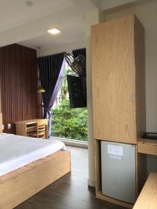 a bedroom with a bed and a tv and a window at Hue Four Seasons Hotel in Hue