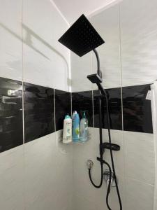 y baño con ducha y lámpara negra. en Moranit, en Moran