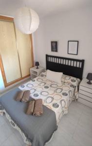 ein Schlafzimmer mit einem Bett mit zwei Hausschuhen darauf in der Unterkunft Apartamento Buenavista Roquetas de Mar in Roquetas de Mar
