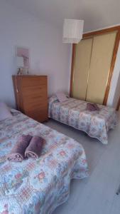 1 Schlafzimmer mit 2 Betten und einer Holzkommode in der Unterkunft Apartamento Buenavista Roquetas de Mar in Roquetas de Mar