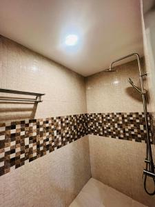 um chuveiro na casa de banho com uma parede em azulejo em Samba Bluewater Resort em Olongapo