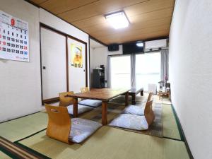 a dining room with a table and chairs in a room at 民宿かず in Sosa