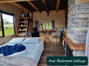 a bed in a room with a stone wall at Swiss-Kiwi Retreat A self-contained Appartment and a Tiny House option in Tauranga