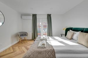 a bedroom with a large bed and a chair at Lion Apartments - Comfy Sopot Family House in Sopot
