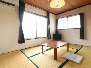 a room with a table and two windows at 民宿かず in Sosa