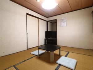 a room with a table and a tv in it at 民宿かず in Sosa