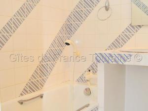 y baño con ducha y azulejos azules y blancos. en Gîte Azay-le-Rideau, 3 pièces, 4 personnes - FR-1-381-279, en Azay-le-Rideau