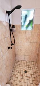 una doccia con soffione nero in bagno di The Haven View - Airlie Beach ad Airlie Beach