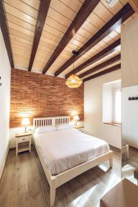 ein Schlafzimmer mit einem Bett und einer Ziegelwand in der Unterkunft El Refugio De Chilla Alojamientos 1 in Candeleda