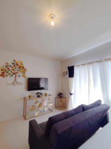 a living room with a couch and a tv at Palawan Paradise Condotel 7F in Puerto Princesa City