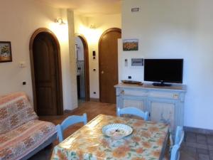 ein Wohnzimmer mit einem Tisch und einem TV in der Unterkunft Casamare Gianluca in Marina di Massa