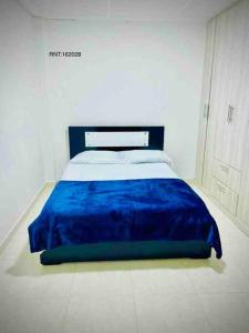 a bedroom with a bed with a blue blanket at Rincón Familiar-en Corredor Turistico -SRC in Santa Rosa de Cabal