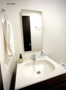 a bathroom with a white sink and a mirror at Rincón Familiar-en Corredor Turistico -SRC in Santa Rosa de Cabal