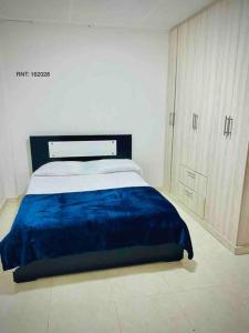 a bedroom with a bed with a blue blanket on it at Rincón Familiar-en Corredor Turistico -SRC in Santa Rosa de Cabal