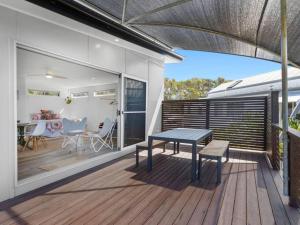 a patio with a table and chairs on a deck at Casuarina Cove in Casuarina