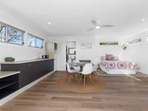 a kitchen and living room with a table and chairs at Casuarina Cove in Casuarina