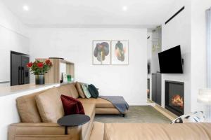 a living room with a couch and a fireplace at Mod House Ocean Grove- Walk to the shops, cafes, beach and park! Brand new luxury apartment in gated complex in Ocean Grove