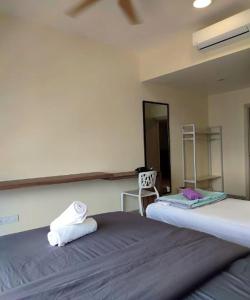 a bedroom with two beds and a chair in it at Mid Vally Southkey JB, 2BR, WIFI, 7 mins to CIQ in Johor Bahru