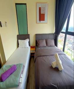 two beds sitting next to each other in a room at Mid Vally Southkey JB, 2BR, WIFI, 7 mins to CIQ in Johor Bahru
