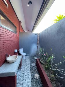 a bathroom with a sink and a toilet at Tebu menjangan homestay in Banyuwedang